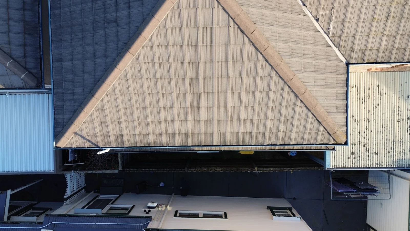 Overhead drone photograph of a tiled residential roof and surrounding roof edges